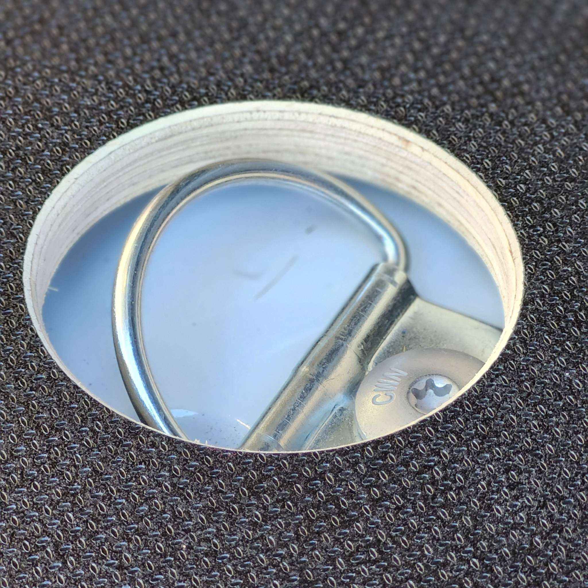 Un trou sur le plancher Edelclick, pour accéder à la boucle d'arrimage fixée à la carrosserie du véhicule utilitaire.